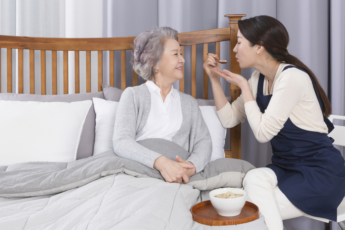 Asian caregiver and old woman at nursing home