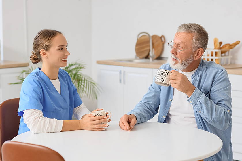 senior-man-nurse-drinking-tea-kitchen